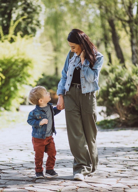 Mother and toddler walking together in the park — choosing the right supportive shoes for early walkers